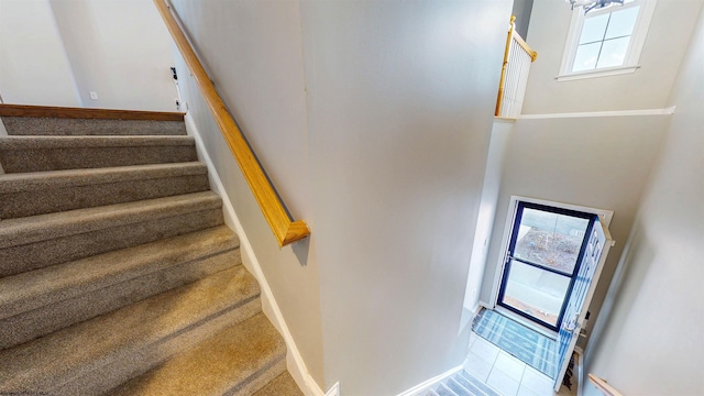 stairway featuring carpet flooring and baseboards