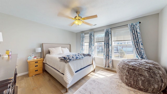 bedroom with visible vents, light wood-style flooring, baseboards, and ceiling fan