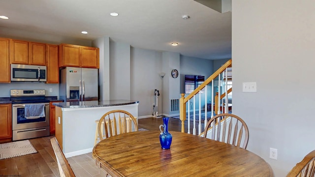 dining space featuring visible vents, dark wood-type flooring, recessed lighting, stairway, and baseboards