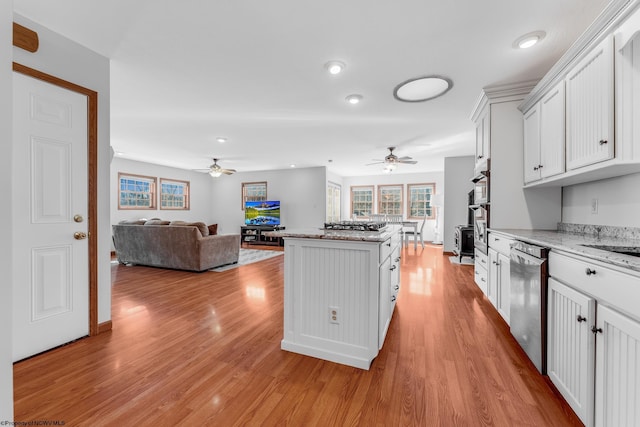 kitchen with light wood finished floors, open floor plan, a center island, and stainless steel appliances