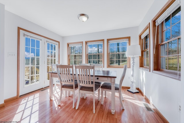 dining room featuring visible vents, baseboards, and light wood-style flooring