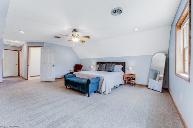 carpeted bedroom with vaulted ceiling, baseboards, and visible vents