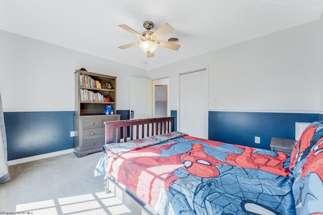 carpeted bedroom with visible vents, baseboards, and a ceiling fan