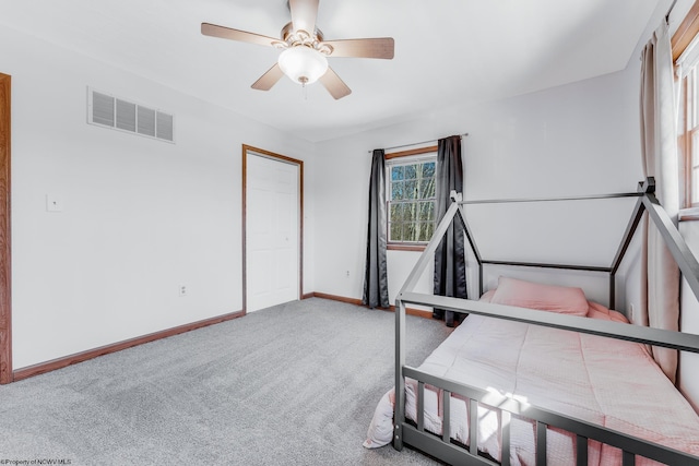 unfurnished bedroom with a ceiling fan, carpet flooring, baseboards, and visible vents