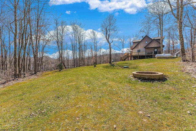 view of yard with a wooden deck, a fire pit, and stairway