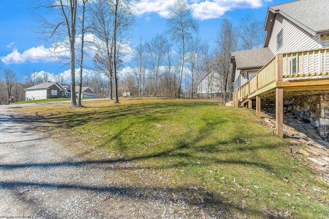 view of yard with a wooden deck and driveway