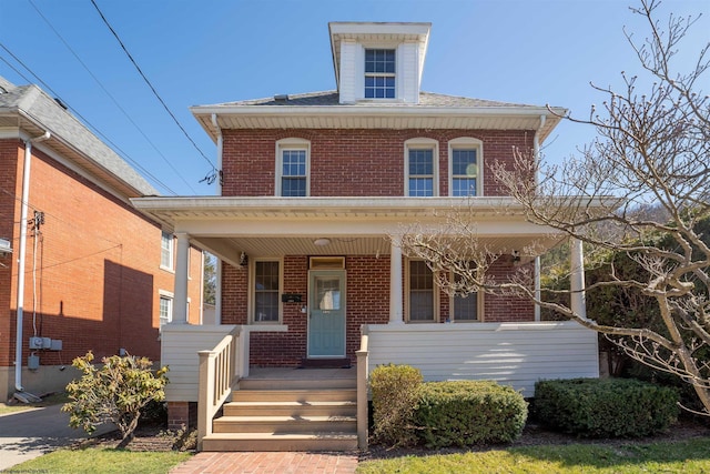 american foursquare style home with brick siding and a porch