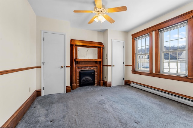 unfurnished living room with baseboards, carpet floors, ceiling fan, a baseboard heating unit, and a brick fireplace