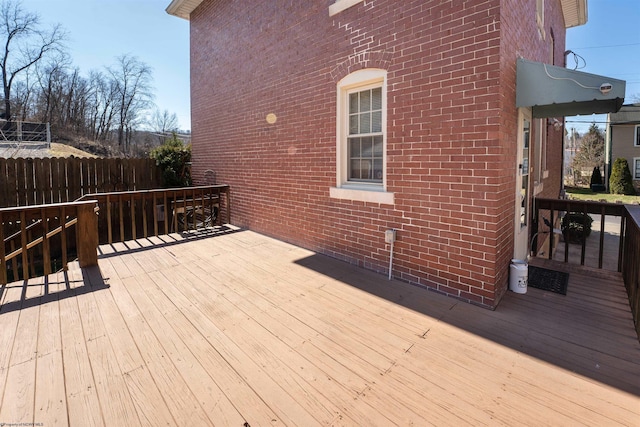 wooden terrace featuring fence