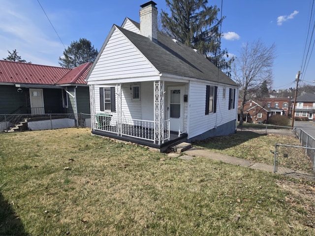 bungalow-style home featuring a porch, a chimney, a front lawn, and fence