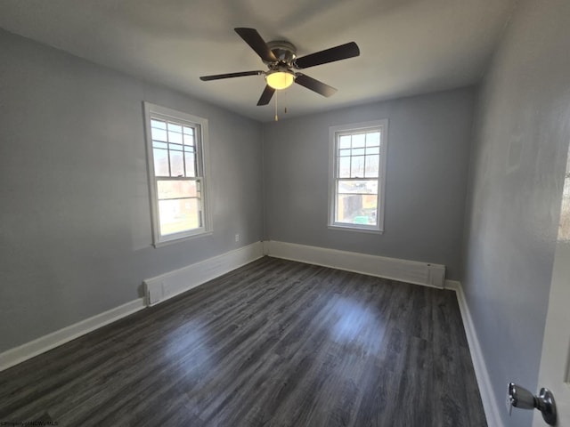 unfurnished room with dark wood-style floors, a healthy amount of sunlight, and baseboards