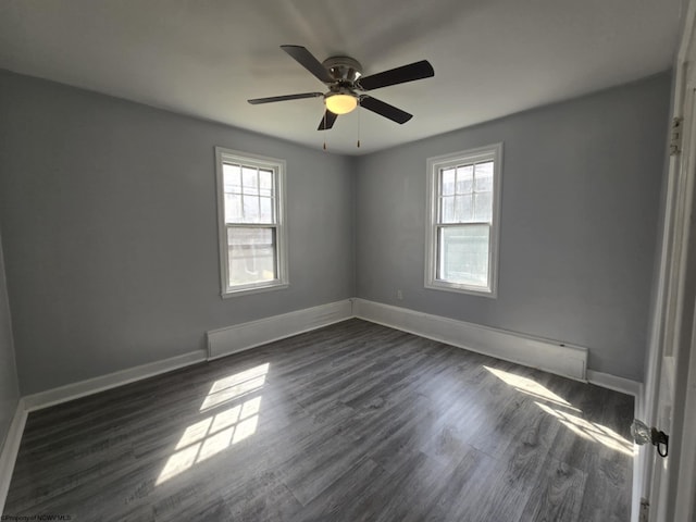 spare room with dark wood finished floors, baseboards, a wealth of natural light, and ceiling fan