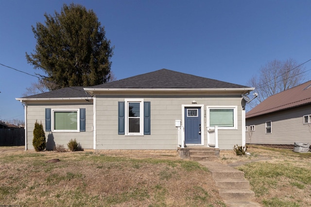 view of front of home with a front lawn and roof with shingles