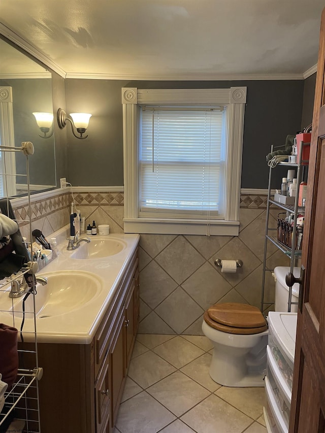 bathroom with tile patterned flooring, toilet, crown molding, and a sink