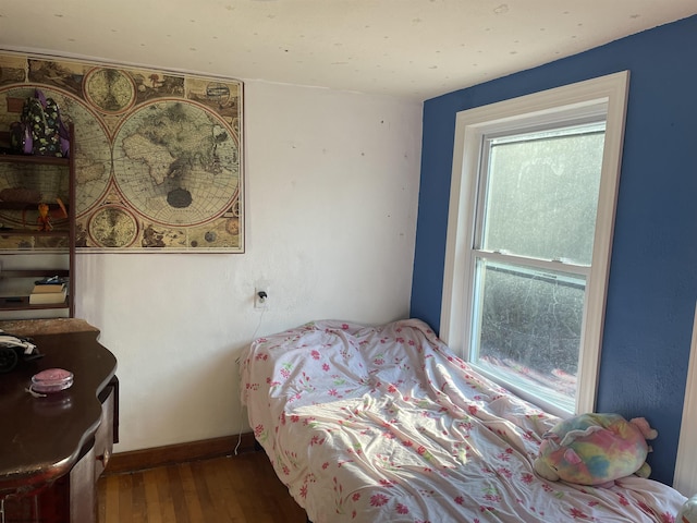 bedroom featuring baseboards and wood finished floors