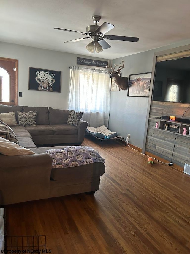 living area with ceiling fan, visible vents, and wood finished floors