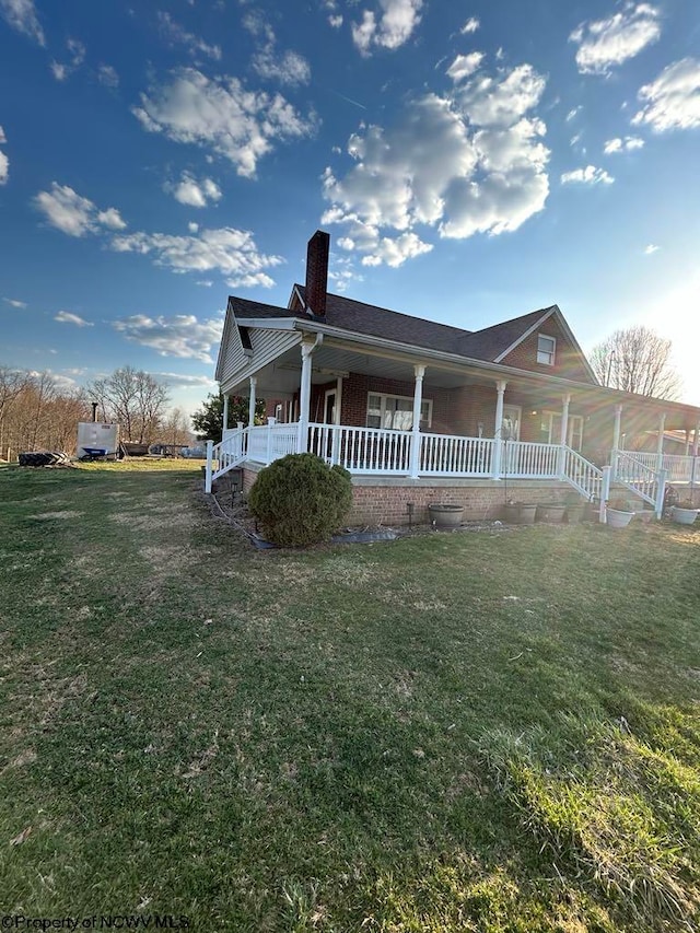 exterior space featuring a front yard, covered porch, and a chimney