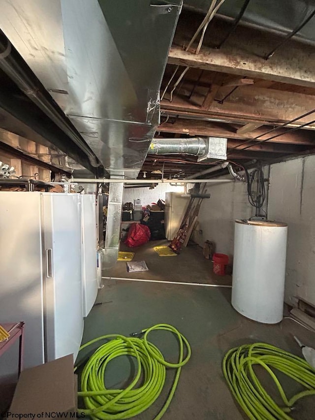 unfinished basement featuring water heater and freestanding refrigerator