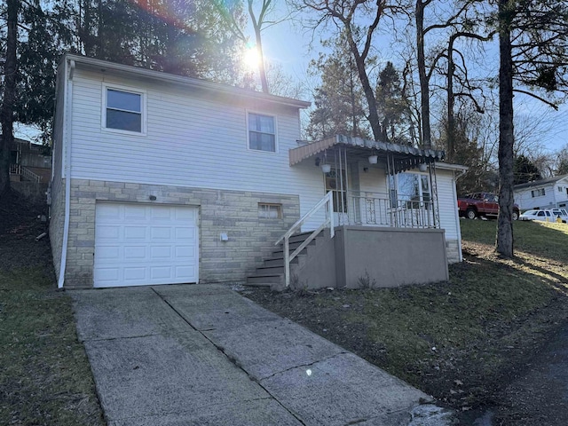 tri-level home featuring stone siding, concrete driveway, and an attached garage