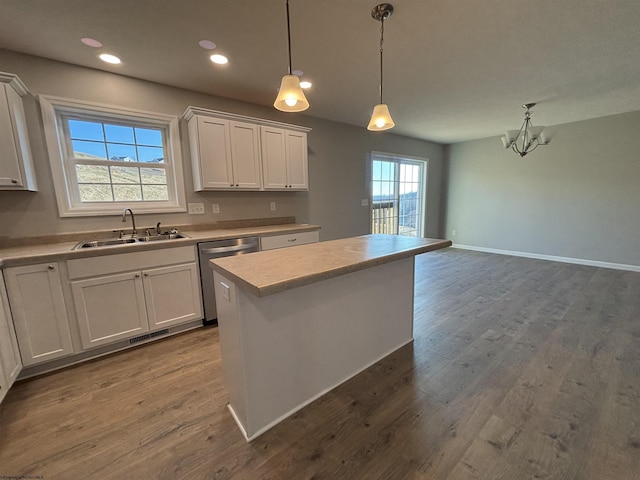 kitchen featuring visible vents, a sink, light countertops, stainless steel dishwasher, and dark wood-style flooring