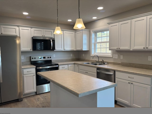 kitchen featuring pendant lighting, a sink, a center island, recessed lighting, and stainless steel appliances