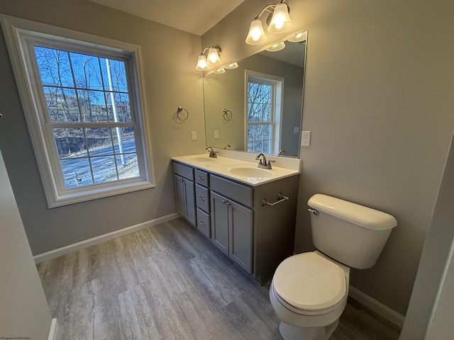 full bath featuring a healthy amount of sunlight, baseboards, and a sink