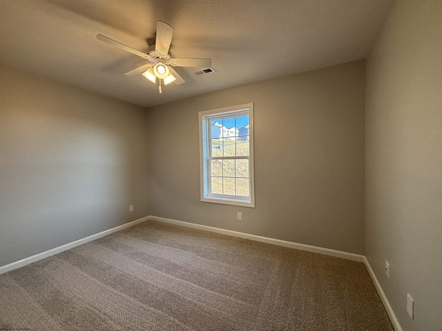 carpeted empty room with visible vents, baseboards, and ceiling fan