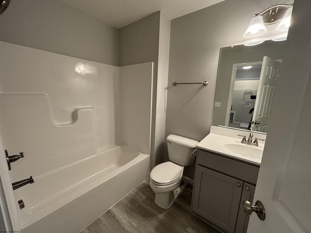 full bathroom with bathtub / shower combination, toilet, wood finished floors, and vanity