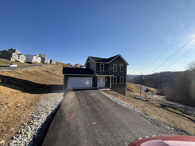 traditional-style home featuring aphalt driveway and a garage