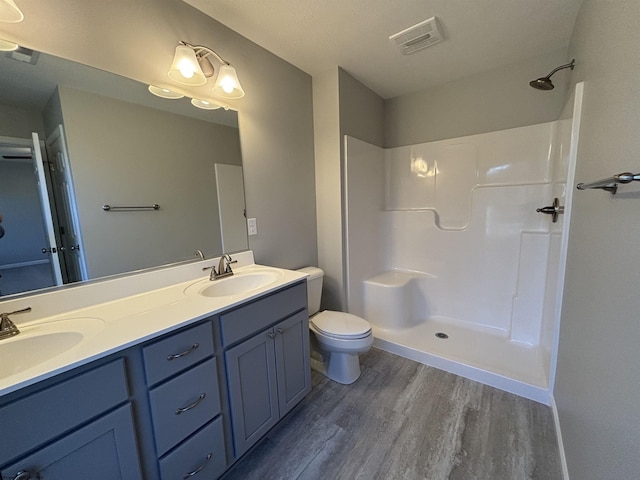 full bathroom with a shower, wood finished floors, visible vents, and a sink