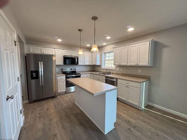 kitchen with a sink, stainless steel appliances, dark wood-style flooring, and white cabinetry