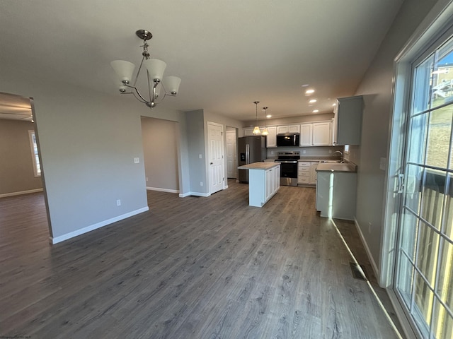 kitchen featuring baseboards, dark wood finished floors, white cabinets, appliances with stainless steel finishes, and open floor plan