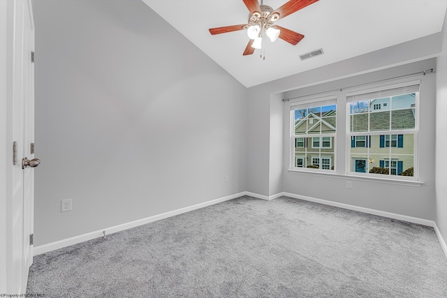 spare room featuring carpet, baseboards, visible vents, lofted ceiling, and ceiling fan