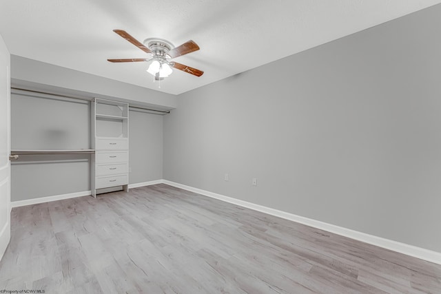 unfurnished bedroom featuring light wood-style flooring, a ceiling fan, baseboards, and a closet