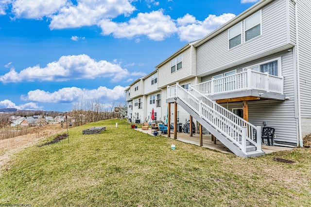 exterior space featuring a lawn, a deck, stairway, a residential view, and a patio area