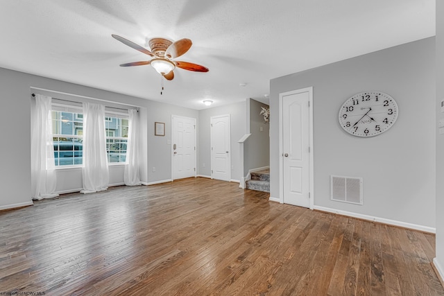 unfurnished living room featuring hardwood / wood-style floors, visible vents, and ceiling fan