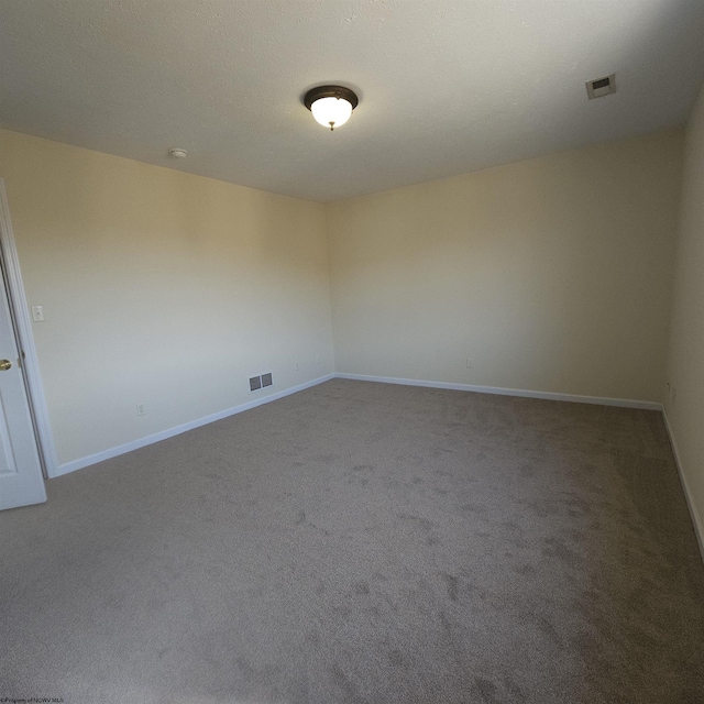 empty room with visible vents, baseboards, and carpet flooring