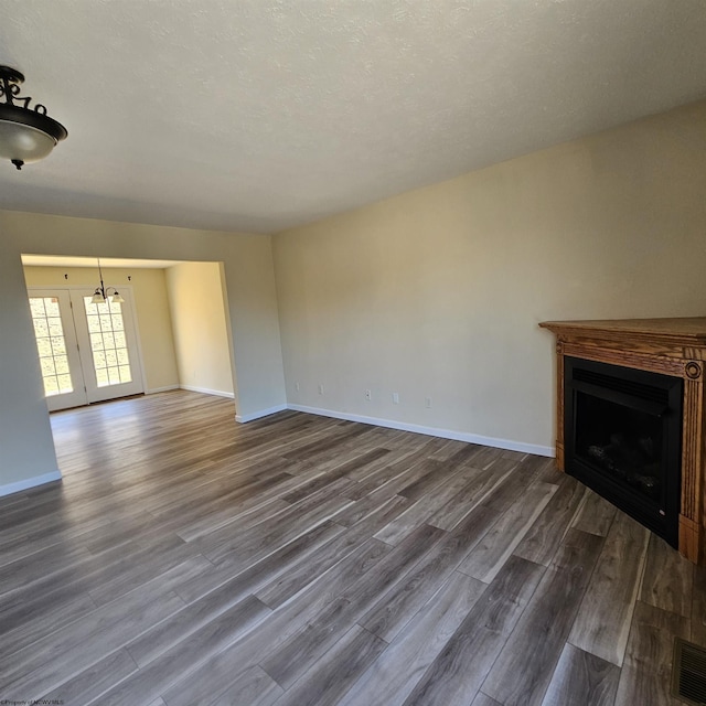 unfurnished living room with visible vents, a fireplace, dark wood-type flooring, and baseboards