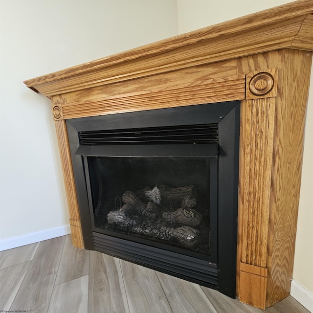 interior details with wood finished floors, a fireplace, and baseboards