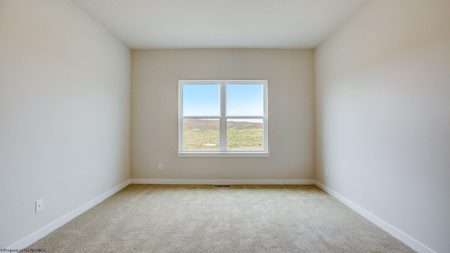 carpeted empty room featuring visible vents and baseboards