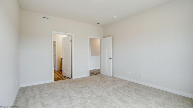 unfurnished bedroom featuring carpet flooring, visible vents, and baseboards