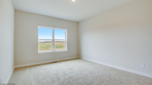 carpeted empty room featuring visible vents and baseboards