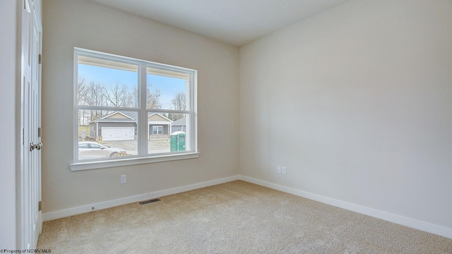 carpeted spare room featuring visible vents and baseboards