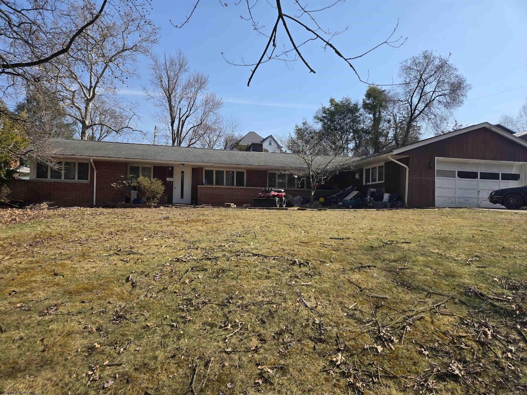 ranch-style house featuring a front lawn and an attached garage