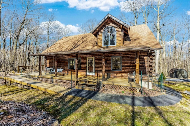 rear view of house with covered porch and log exterior