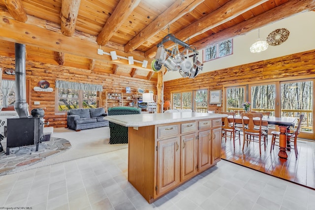 kitchen featuring wood ceiling, open floor plan, a wood stove, and light countertops