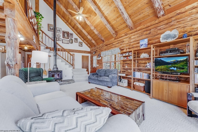 carpeted living room featuring beam ceiling, a wood stove, wood ceiling, and high vaulted ceiling