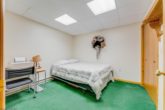 bedroom featuring a drop ceiling, carpet floors, and baseboards