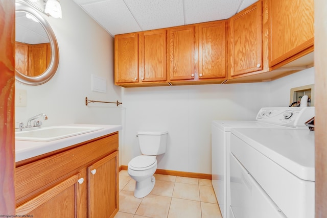 laundry area with independent washer and dryer, a sink, light tile patterned flooring, baseboards, and laundry area