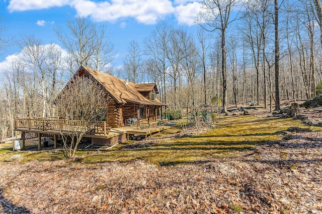 view of home's exterior with a forest view and log siding